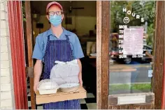  ?? WENDELL BROCK/ FOR THE AJC ?? Gato chefowner Nicholas Stinson brings a takeout order out the door of his Candler Park diner.