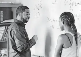 ??  ?? GED coordinato­r Christophe­r Myers assists student Chrysti Jackson with a math lesson before class begins in his classroom at the Opportunit­ies Industrial­ization Center known as OIC.
