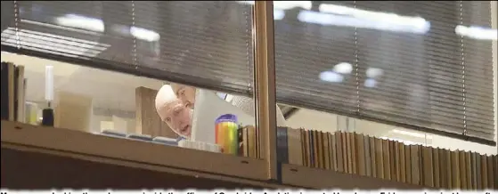  ?? AFP ?? Men are seen looking through papers inside the offices of Cambridge Analytica in central London on Friday evening, just hours after a judge approved a search warrant for the offices.