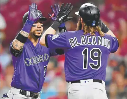  ?? By Patrick Saunders Jamie Sabau, Getty Images ?? Rockies right fielder Carlos Gonzalez celebrates his three-run homer in the seventh inning with center fielder Charlie Blackmon on Tuesday night in Cincinnati at Great American Ball Park.