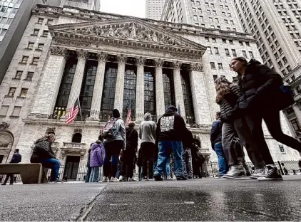  ?? Peter Morgan/associated Press ?? People walk past the New York Stock Exchange on Wednesday. Wall Street set records again Thursday as U.S. markets closed out another winning month and quarter.