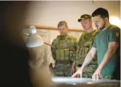  ?? UKRAINIAN PRESIDENTI­AL PRESS SERVICE ?? Ukrainian President Volodymyr Zelenskyy, right, looks at a map on Friday during a visit with army troops stationed in the Dnipro region.