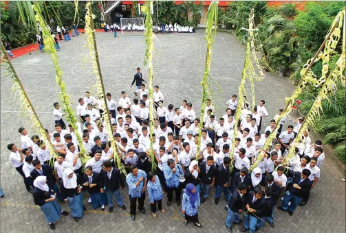  ?? ALLEX QOMARULLA/JAWA POS ?? JAGA TRADISI: Para siswa SMAN 6 Surabaya menghias penjor di pekarangan sekolah kemarin. Penjor merupakan simbol menyambut hajat besar dengan kebahagiaa­n.