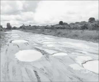  ??  ?? A section of the road littered with potholes. The potholes have also started to pop up on the shoulders, which force drivers to drive through them.