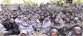  ?? ?? Una imagen de un video de 2014 muestra a las niñas nigerianas secuestrad­as. La escuela incendiada en Chibok, Nigeria, (sup.) donde fueron raptadas por milicianos de Boko Haram.