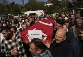  ?? KHALIL HAMRA — THE ASSOCIATED PRESS ?? Turkey’s Interior Minister Suleyman Soylu, right, helps with a coffin for one of the miners killed in a coal mine explosion during his funeral in Amasra in the Black Sea coastal province of Bartin, Turkey, on Saturday.