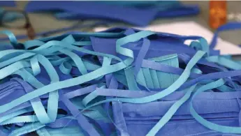  ?? Kevin Mohatt, Special to The Denver Post ?? A pile of masks that were sewn by volunteers Marilyn Conners, her daughter J. J. Harris and granddaugh­ter Sailor Harris were waiting to be delivered to workers at Saint Joseph Hospital in Denver on April 9.