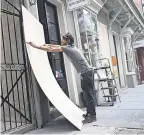  ?? JOE RAEDLE/ GETTY IMAGES ?? Marris Mielnick covers windows in the French Quarter of New Orleans before the storms.