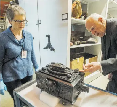  ??  ?? Joan Seidl and real- estate developer and philanthro­pist Michael Audain inspect a box carved out of argillite by Charles Edenshaw at the Museum of Vancouver.