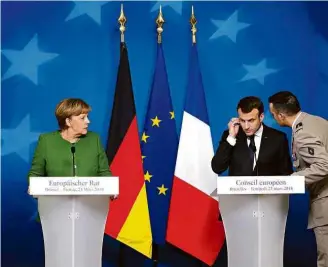  ?? Ludovic Marin/AFP ?? O presidente Emmanuel Macron é informado de ataque ao lado da alemã Angela Merkel