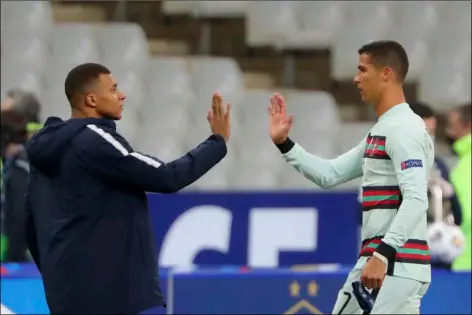  ?? AP PHOTO/THIBAULT CAMUS ?? France’s Kylian Mbappe and Portugal’s Cristiano Ronaldo, right, greet each other at the end of the UEFA Nations League soccer match between France and Portugal at the Stade de France in Saint-Denis, north of Paris, France, Oct. 11.