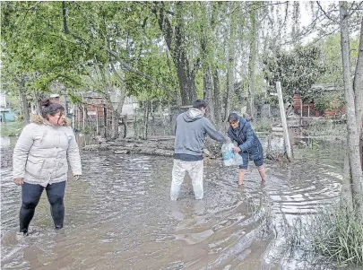  ??  ?? Reparten agua potable a cientos de personas que tienen sus casas inundadas