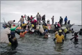  ?? ?? Fisherfolk swim out from an incoming boat at a berth June 12, some with their overnight catch in Kwale County.