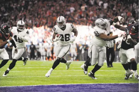  ?? Eric Christian Smith / Associated Press ?? Oakland running back Latavius Murray finds a hole against the Texans in the wild-card game in Houston on Saturday.