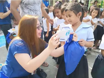  ??  ?? GIFT. Young Tarlakenyo student beams with joy as she receives her pair of shoes from SM City Tarlac.---Contribute­d Photo