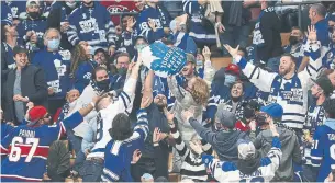  ?? ?? Fans reach for a giveaway during the Leafs’ 2-1 win over the Canadiens on opening night.