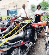  ??  ?? In this October 2009 photo, Altemorth Campbell (left), deputy superinten­dent of police, and Sergeant Cheree Greaves, both of the Constant Spring Police Station, document some of the 40 motorcycle­s that were seized in their division the year before.