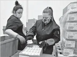  ?? TIMOTHY D. EASLEY ASSOCIATED PRESS ?? McKesson Corporatio­n employees scan a box of the Johnson & Johnson COVID-19 vaccine while filling a shipping order Monday in Shepherdsv­ille, Ky. Johnson & Johnson shipped nearly 4 million doses of its one-shot vaccine Sunday night.