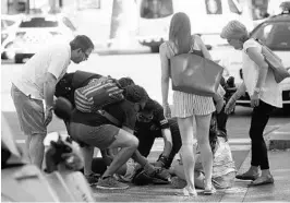  ?? ORIOL DURAN/ASSOCIATED PRESS ?? A person is treated Thursday in Barcelona, Spain, after a white van jumped the sidewalk in the historic Las Ramblas district, crashing into a summer crowd of residents and tourists.