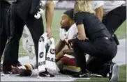  ?? STEVEN SENNE — THE ASSOCIATED PRESS ?? Redskins running back Derrius Guice, center, receives attention on the field after an injury against the Patriots, Thursday.