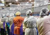  ?? Associated Press ?? Tyson Foods workers wear protective masks and stand between plastic dividers at the company’s Camilla, Ga., plant.