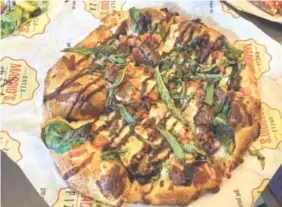  ?? PHOTOS BY SARA JACKSON ?? The Steak & Blue pizza has garlic olive oil, grilled steak, mozzarella, blue cheese, tomatoes, spinach, basil and a drizzle of balsamic glaze.
