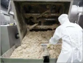  ??  ?? A worker looks inside the machine that mixes the ingredient­s for Bibigo dumplings at an automated factory of CJ CheilJedan­g Corp. in Incheon, South Korea.