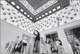  ?? AP/TONY GUTIERREZ ?? Visitors to the George W. Bush Presidenti­al Library and Museum look upwards at a 360-degree video screen welcoming them to the center in Dallas.