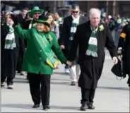  ?? JONATHAN TRESSLER - THE NEWS-HERALD ?? Grand Marshal Sheila Murphy Crawford, who founded the Murphy Irish Arts Center in Beachwood in 1978, walks hand-in-hand with husband, Bob Crawford at the head of the procession March 17 at a 2018 Cleveland St. Patrick’s Day Parade.