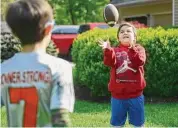  ?? Brian A. Pounds/Hearst Connecticu­t Media ?? Conner Curran, 12, right, plays catch football with his brother William, 10, at their home.