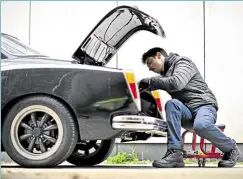  ?? ?? NEW CONVERT A mechanic works on a Volkswagen Karmann Ghia. Quitter says his clients want the ‘reliabilit­y’ of electric cars without the smell and exhaust fumes of a gasoline vehicle.