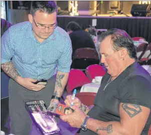  ?? COLIN MACLEAN/JOURNAL PIONEER ?? David Bobbitt, left, gets an action figure signed by one of his childhood heroes, pro wrestler Brutus “The Barber” Beefcake, during the Summerside Boys and Girls Club’s 2017 Celebrity Dinner Gala, Monday evening.