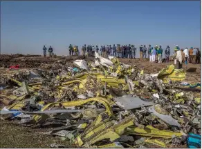  ??  ?? People gather around the wreckage of the Ethiopian Airlines plane on March 11, 2019, a day after the crash near Addis Ababa that killed all 157 people on board. (AP/Mulugeta Ayene)