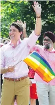  ??  ?? Prime Minister Justin Trudeau marches in the Vancouver Pride Parade on Sunday with Minister of Defence Harjit Sajjan.