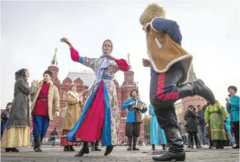  ?? — AFP ?? Dancers in traditiona­l Russian costume perform outside The Kremlin in Moscow on Friday.