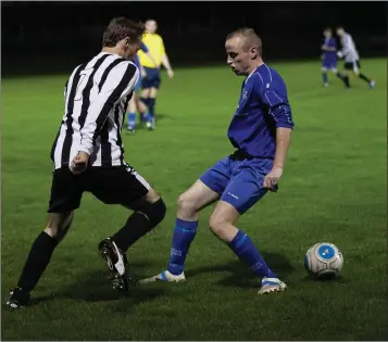  ??  ?? Arklow Town’s Paul Kelty nutmegs Frank Byrne of Aughrim Rangers.