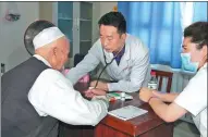  ?? PROVIDED TO CHINA DAILY ?? Tang Baopeng (middle), deputy director of the First Affiliated Hospital of Xinjiang University, is examining a patient during a free diagnosis in Bacu county, Xinjiang.