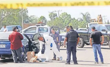  ??  ?? Peritos ministeria­les trabajan en la zona donde un grupo armado asesinó ayer al director operativo de la Policía del municipio de El Salto y dejó herido a uno de sus compañeros.