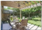  ?? ?? The backyard is fully fenced and has elevated landscapin­g beds, a patio with a pergola and another patio.