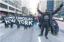  ?? MARY ALTAFFER AP ?? Activists demanding Gov. Andrew Cuomo’s resignatio­n block traffic outside his office Wednesday in New York.