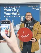  ?? AP ?? Jared Mollenkof, who had waited overnight outside the Minneapoli­s Early Voting Center, was among the first voters in the 2020 election when the center opened at 8 a. m. Friday.