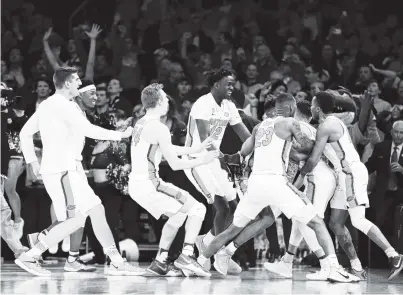  ?? THE ASSOCIATED PRESS ?? Florida players celebrate after a last-second shot by guard Chris Chiozza to beat Wisconsin 84-83 in overtime of Friday’s NCAA tournament East Regional semifinal in New York.