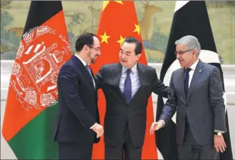  ?? WANG ZHUANGFEI / CHINA DAILY ?? Foreign Minister Wang Yi is flanked by Afghan Foreign Minister Salahuddin Rabbani (left) and Pakistani Foreign Minister Khawaja Muhammad Asif in Beijing on Tuesday for the first China-Afghanista­n-Pakistan Foreign Ministers’ Dialogue.