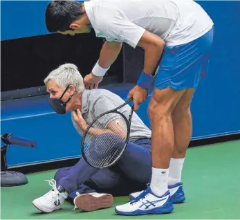  ?? FOTO: SETH WENIG/DPA ?? Atemberaub­ender Treffer: Novak Djokovic versucht, der verletzten Linienrich­terin zu helfen.