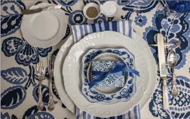  ?? MARY CAROL GARRITY, TNS ?? The place settings are super simple: everyday white plates topped with a sweet blue and white salad plate.