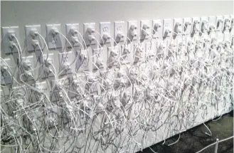  ?? SAL PIZARRO/STAFF ?? Imin Yeh, a San Jose State lecturer who is taking a faculty position at Carnegie Mellon University, created a wall of electric outlets, iPhone chargers and cords entirely out of paper for her last Bay Area show, which features 17 Bay Area artists using...