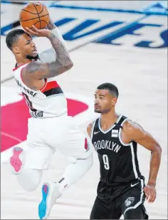  ?? Ashley Landis The Associated Press ?? Trail Blazers guard Damian Lillard lines up a shot over Nets guard Timothe Luwawu-cabarrot in the first half of Portland’s 134-133 win Thursday at the Wide World of Sports Complex.