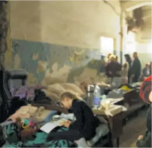  ?? ?? A woman holds a child as they seek shelter in a bomb shelter in the Ukrainian port city of Mariupol.