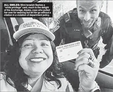  ?? ?? ALL SMILES: Mimi Israelah flashes a “white privilege” card, much to the delight of the Anchorage, Alaska, cops who pulled her over for weaving but let her go without a citation in a violation of department policy.