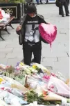  ??  ?? AN ARIANA GRANDE fan stands next to floral tributes left for the victims of an attack on concert goers at Manchester Arena, in St. Ann’s Square, in Manchester, Britain on May 24.